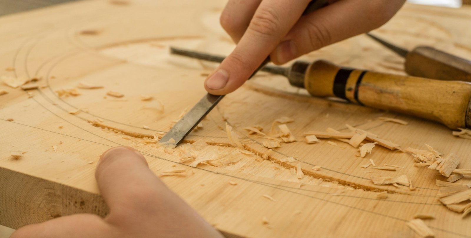 Craftsman's hands finishing a hand-cut joint on fine oak timber